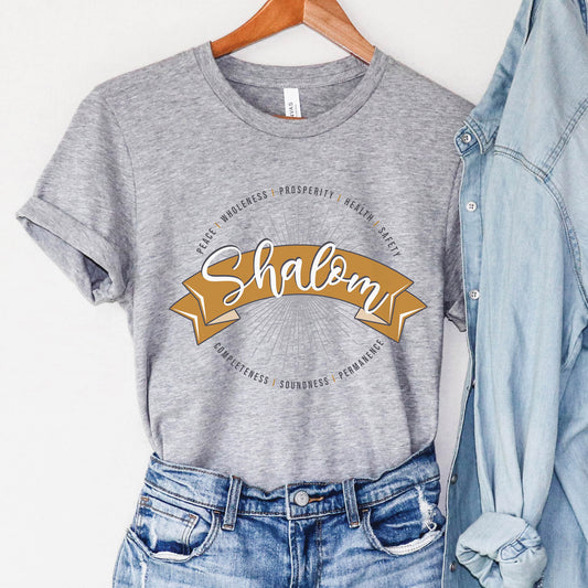 Soft athletic heather gray faith-based Christian women's unisex t-shirt with a gold banner and sunburst design that says the Biblical Hebrew meaning of the word "SHALOM" - Peace, Completeness, Prosperity, Health, Safety, Wholeness, Soundness, and Permanence definition, makes a great mother's day gift for mom!