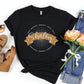 Soft black faith-based Christian women's unisex t-shirt with a gold banner and sunburst design that says the Biblical Hebrew meaning of the word "SHALOM" - Peace, Completeness, Prosperity, Health, Safety, Wholeness, Soundness, and Permanence definition, makes a great mother's day gift for mom!