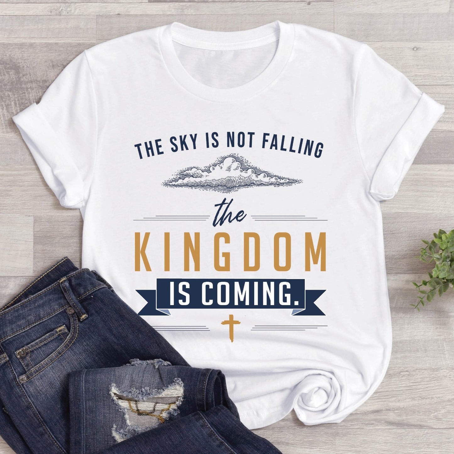 White unisex t-shirt with a Christian Kingdom of God through Jesus faith-based message that says, "The Sky Is Not Falling, The Kingdom is Coming" with bold font, vintage clouds, banner, and cross design in navy blue and gold, created for bible study Men and Women believers, 2024 eclipse
