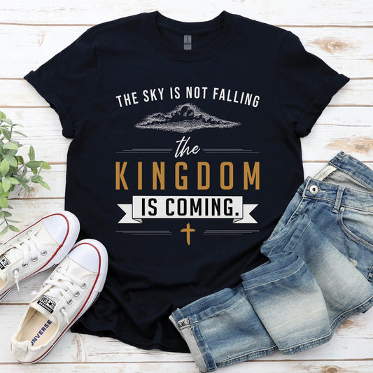 Black unisex t-shirt with a Christian Kingdom of God through Jesus faith-based design that says, "The Sky Is Not Falling, The Kingdom is Coming" with bold font, vintage clouds, banner, and cross design in white and gold, created for bible study Men and Women believers, 2024 eclipse