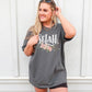 Woman wearing oversized faith based Selah tee / Psalms watercolor floral Christian aesthetic printed in white peach blush pink on soft asphalt charcoal gray t-shirt for women