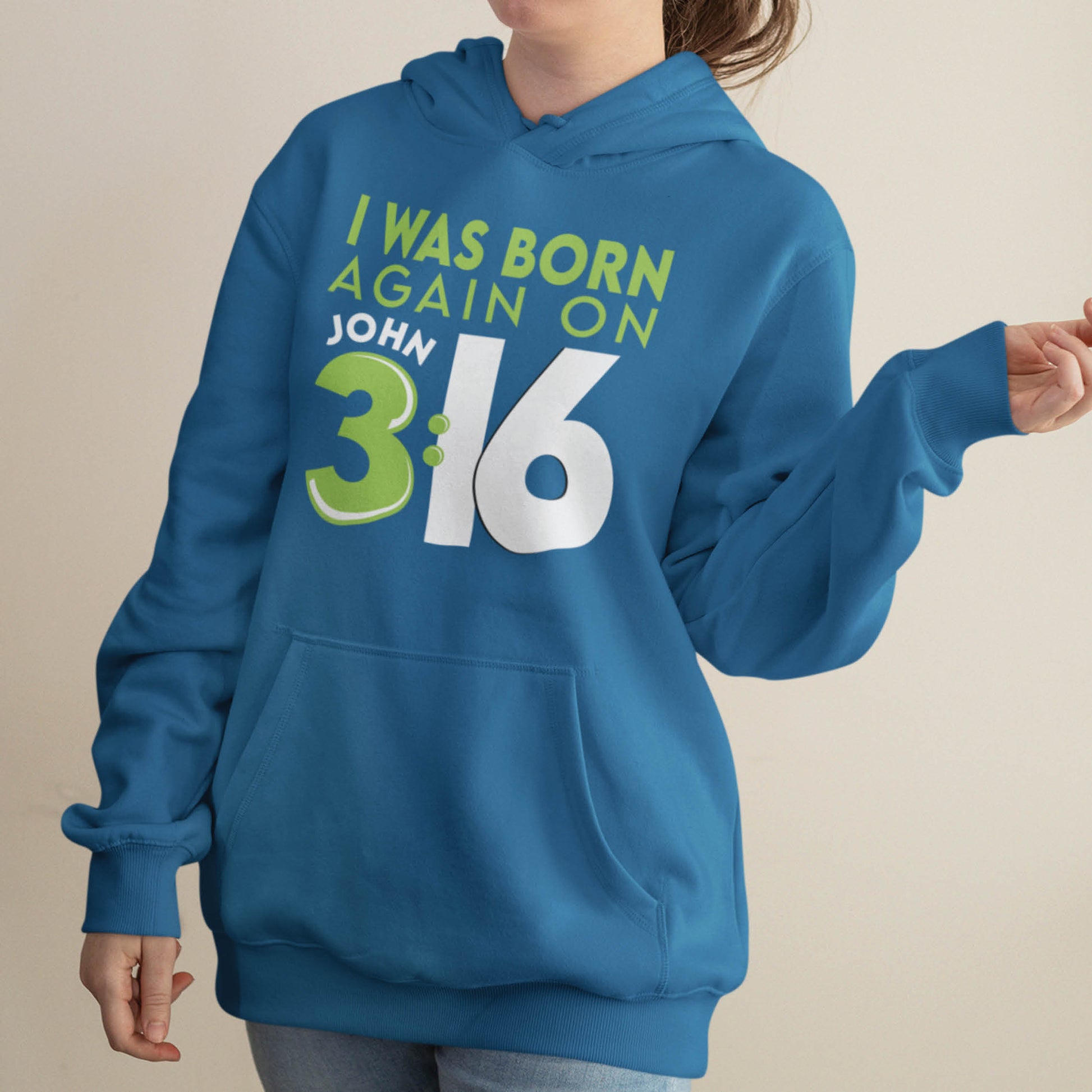 trendy young lady wearing indigo blue Unisex Cozy Hoodie with Christian aesthetic bible verse message that says, "I Was Born Again On John 3:16" bible verse quote in lime green and white for men and women