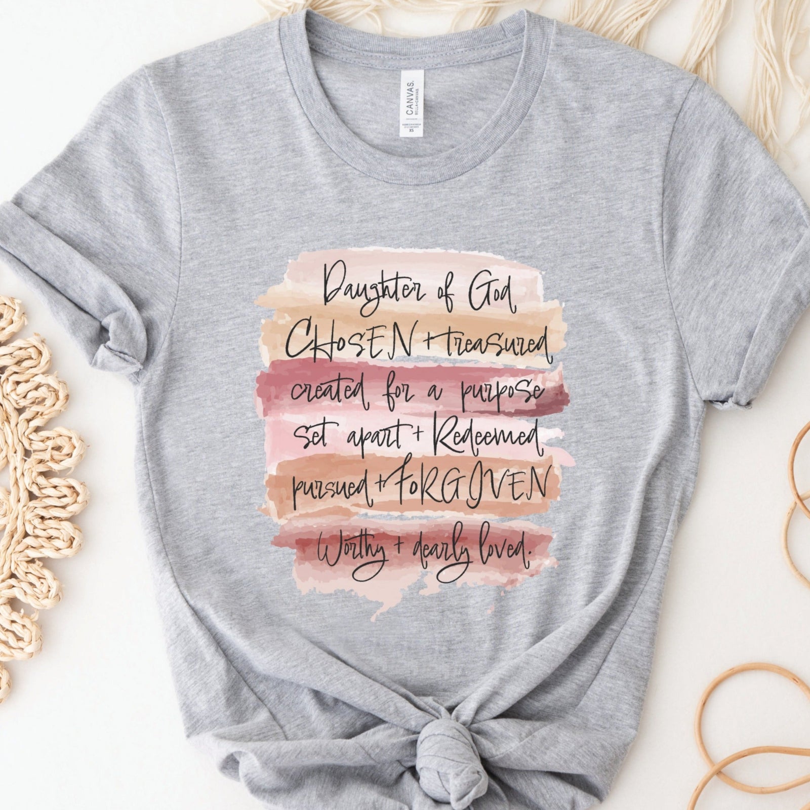 Daughter of God, Chosen, created for a purpose, redeemed, forgiven, worthy, loved, Christian woman aesthetic with neutral colors watercolor splash background printed on soft heather gray unisex t-shirt for women