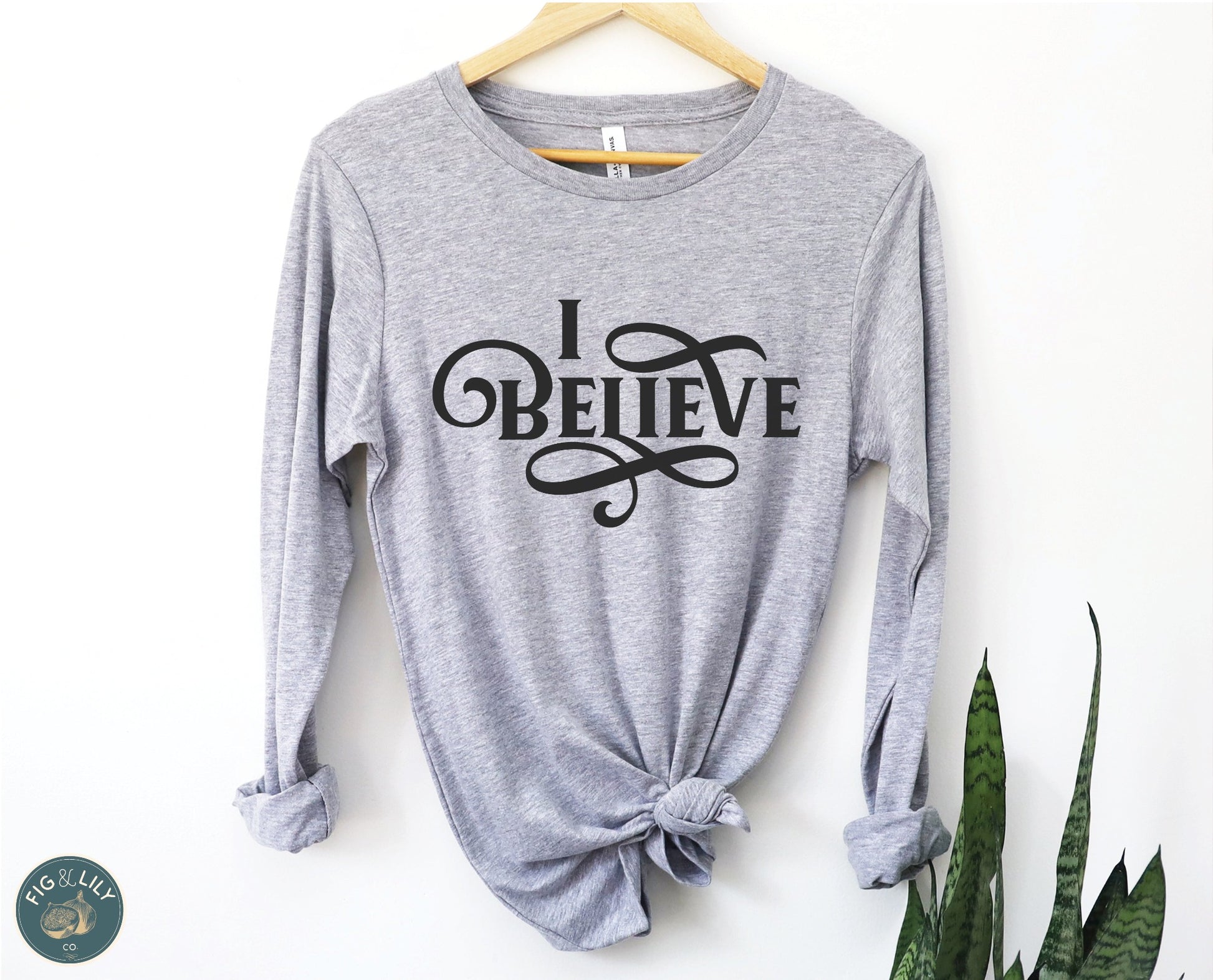 I Believe Swirl Christian aesthetic faith statement design printed in black on soft athletic heather gray long sleeve tee for women