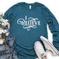 I Believe Swirl Christian aesthetic Jesus believer design printed in white on soft heather deep teal long sleeve tee for women