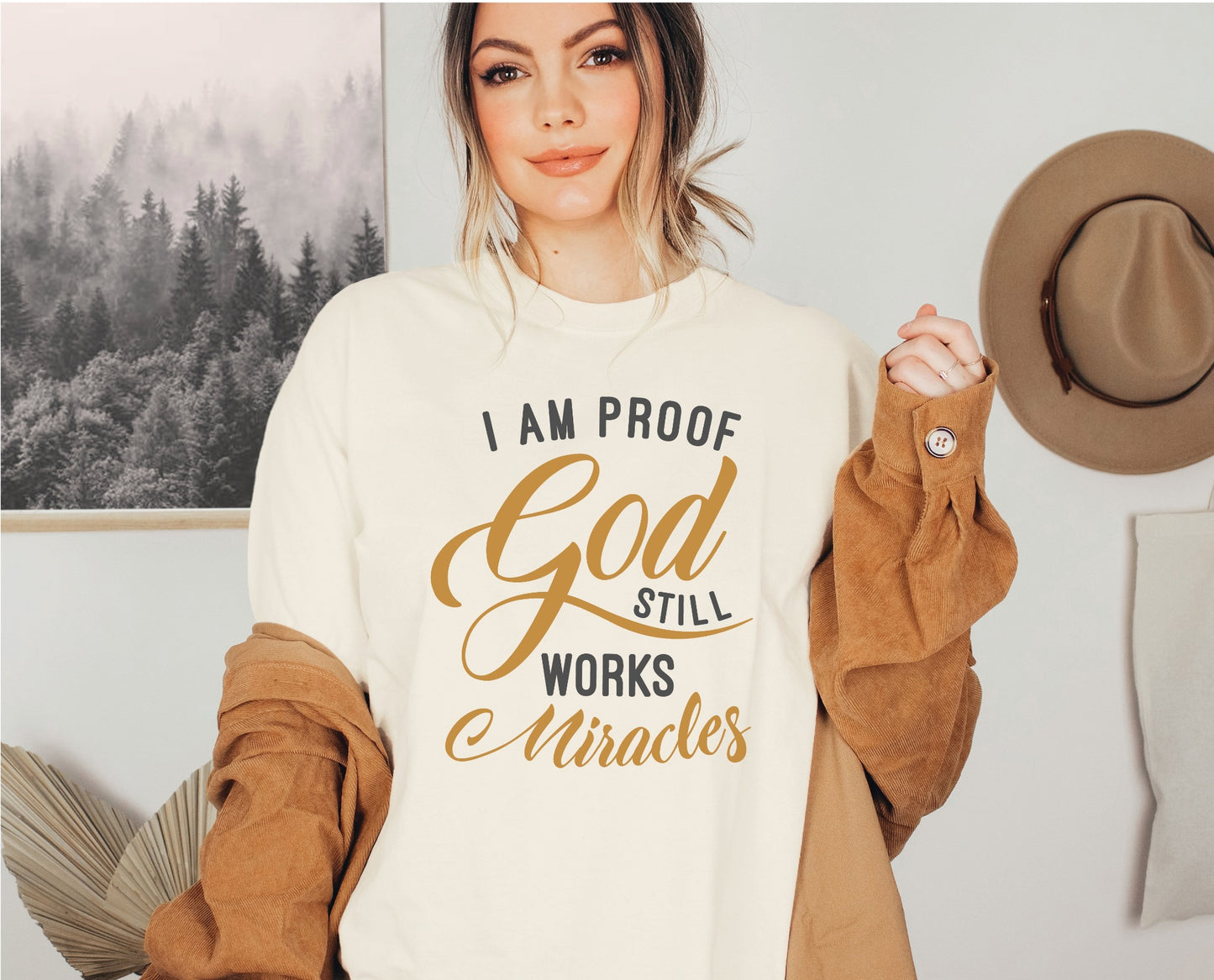 I am proof God still works miracles Christian aesthetic testimony design printed in charcoal and gold on soft cream unisex t-shirt for women