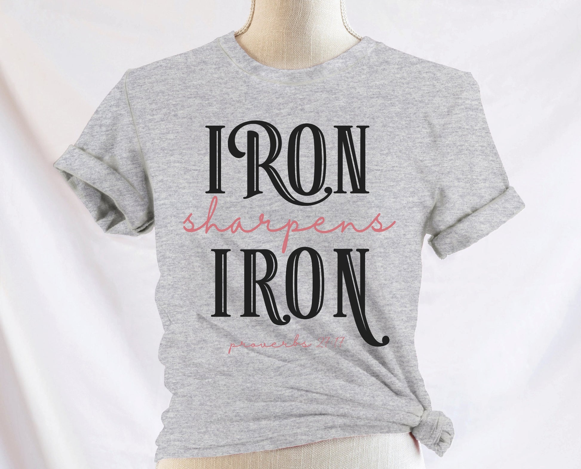 Iron Sharpens Iron Proverbs 27:17 Christian aesthetic design printed in black and mauve on ladies soft heather gray unisex t-shirt for women's groups