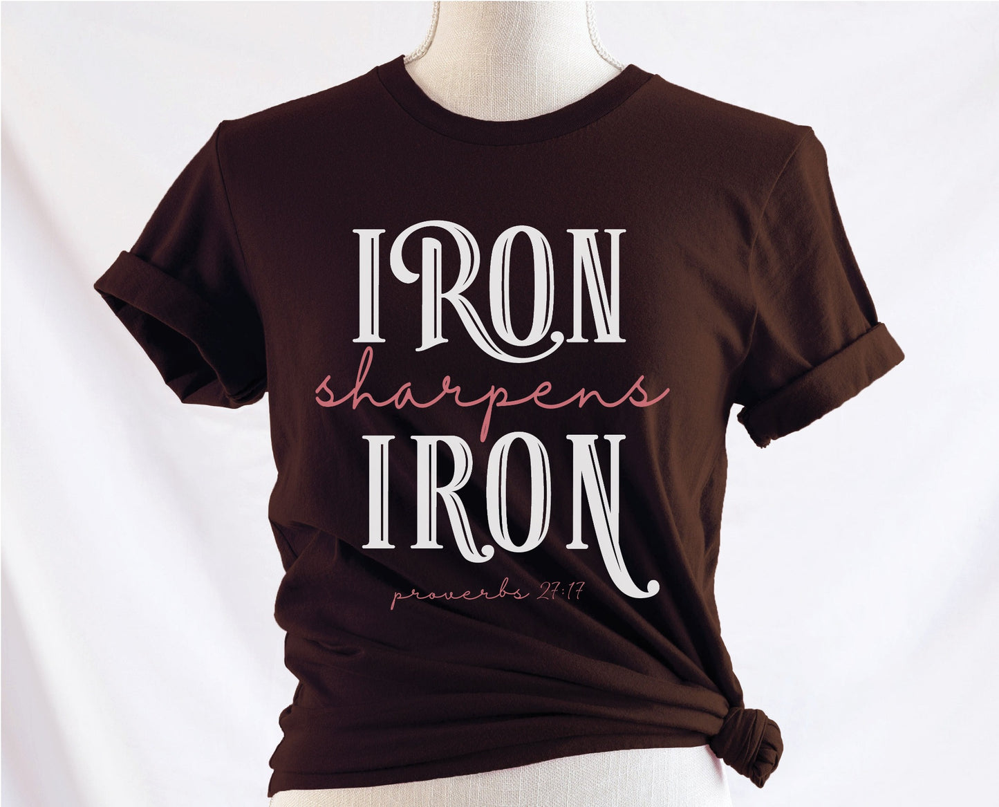 Iron Sharpens Iron Proverbs 27:17 Christian aesthetic design printed in white and mauve on ladies soft brown unisex t-shirt for women's groups