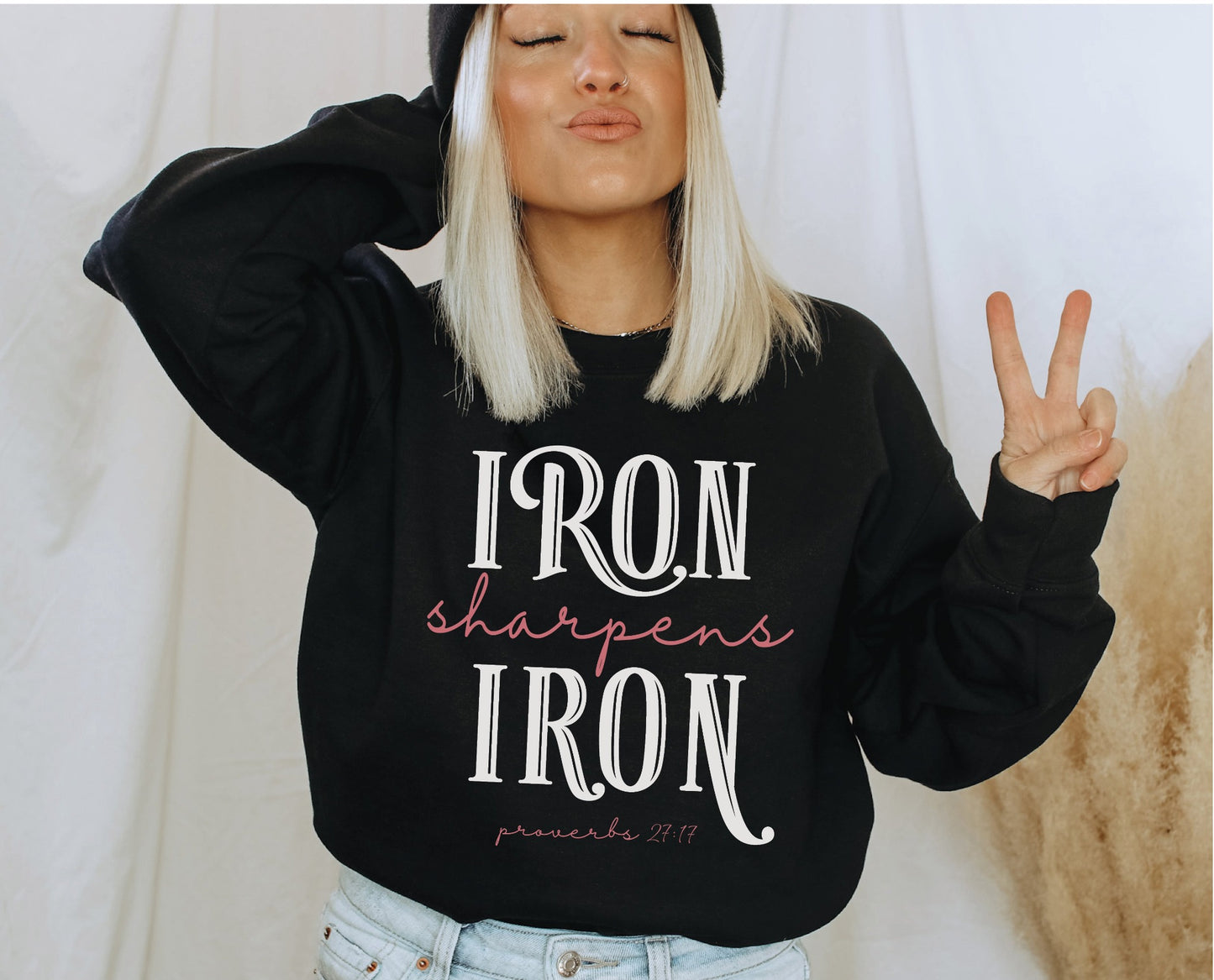 Iron Sharpens Iron Proverbs 27:17 Christian aesthetic design printed in white and mauve on cozy black unisex crewneck sweatshirt for women's groups