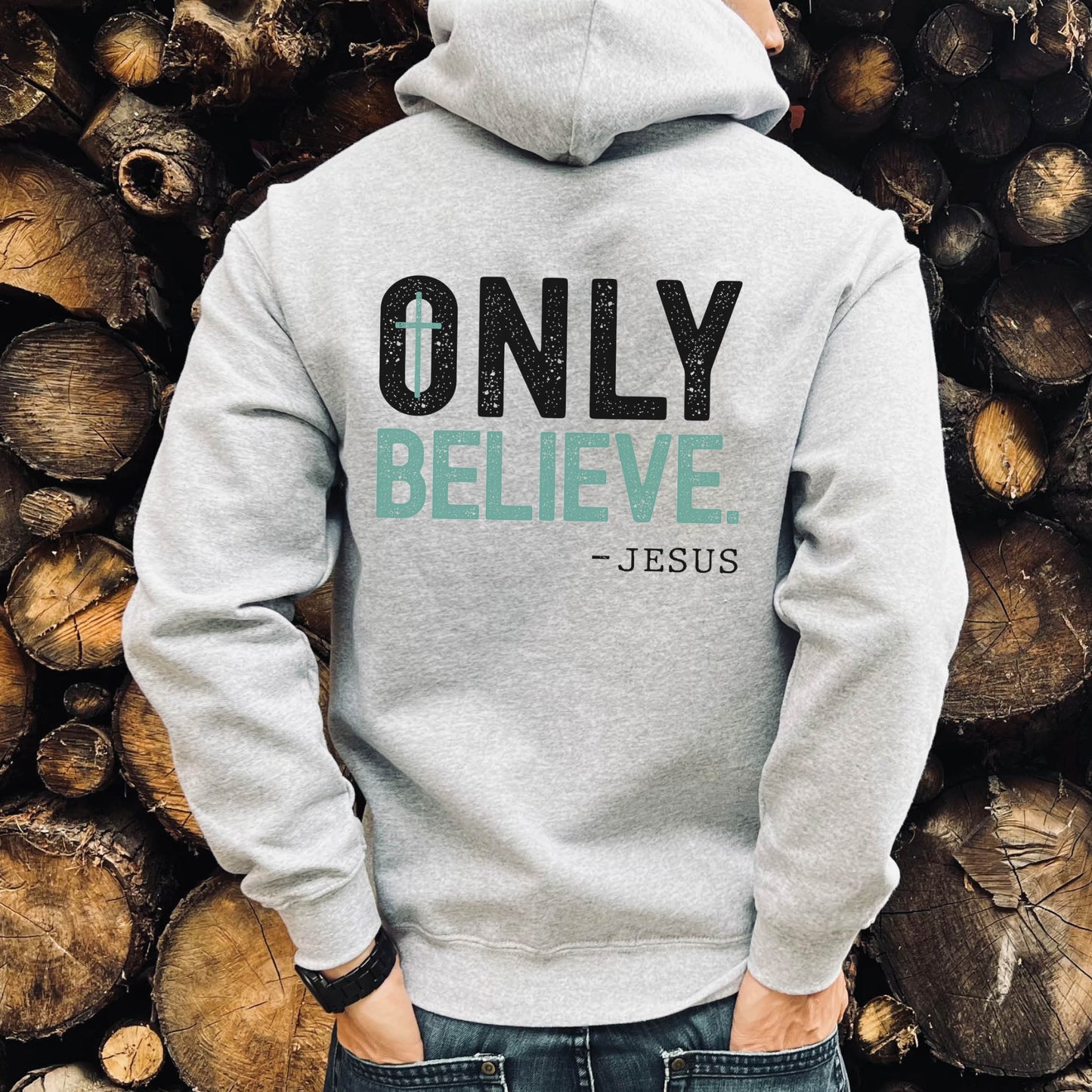 Young man wearing a Do Not Be Afraid Only Believe Jesus Quote Mark 5:36 healing miracle bible verse textured white and teal Christian aesthetic printed on front and back of cozy heather gray unisex hoodie sweatshirt for men and women