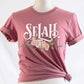 Selah Psalm bible verse watercolor floral Christian aesthetic design printed in white peach blush pink on soft mauve t-shirt for women