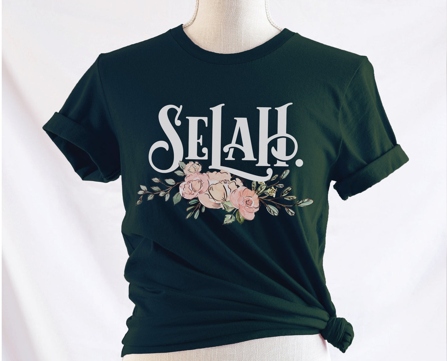 Selah Psalm bible verse watercolor floral Christian aesthetic design printed in white peach blush pink on soft forest green t-shirt for women